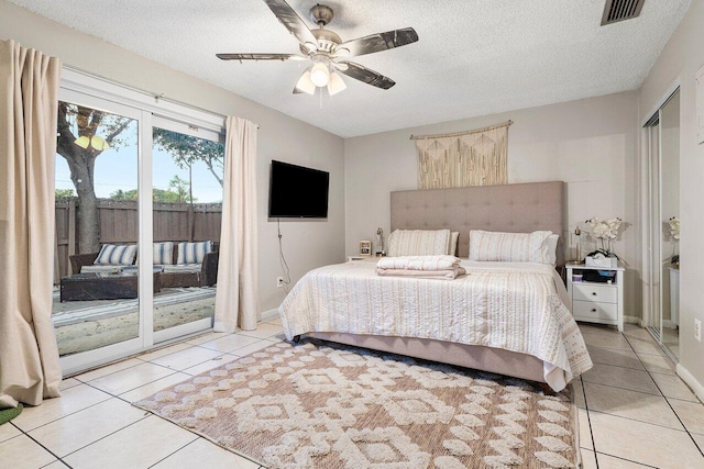 bedroom featuring access to outside, light tile patterned floors, visible vents, and a textured ceiling