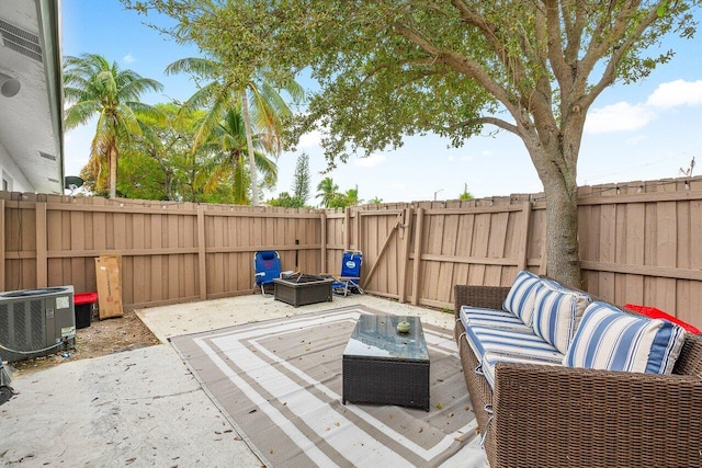 view of patio featuring an outdoor living space with a fire pit, cooling unit, and a fenced backyard