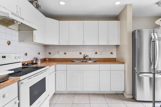 kitchen with light tile patterned floors, freestanding refrigerator, a sink, electric stove, and under cabinet range hood