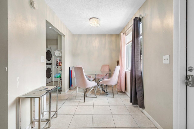 interior space with baseboards, washer / clothes dryer, a textured ceiling, and light tile patterned flooring