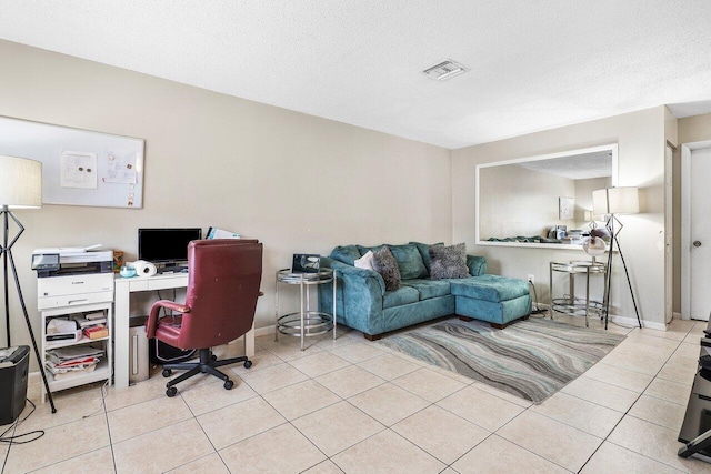 home office featuring light tile patterned flooring, visible vents, and a textured ceiling