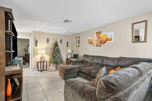 living area featuring visible vents, a textured ceiling, and light tile patterned flooring