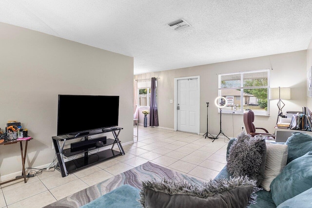 tiled living room featuring a healthy amount of sunlight, visible vents, and a textured ceiling