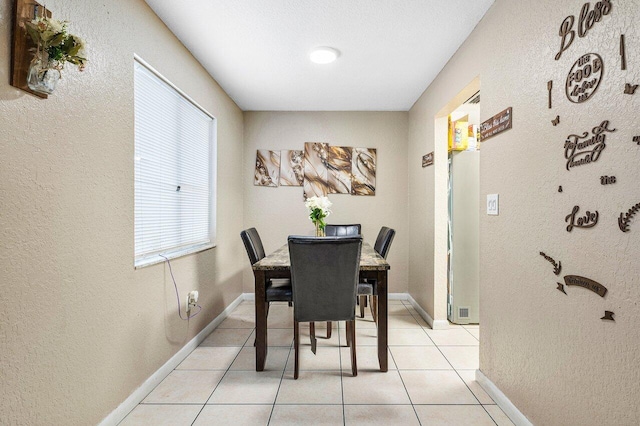 dining area with baseboards and light tile patterned flooring