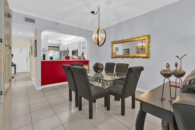 tiled dining space with arched walkways, crown molding, visible vents, an inviting chandelier, and baseboards