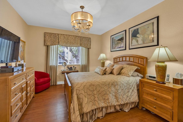 bedroom featuring hardwood / wood-style flooring and a notable chandelier