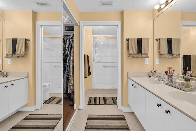 bathroom featuring tile patterned flooring, visible vents, a sink, and a spacious closet