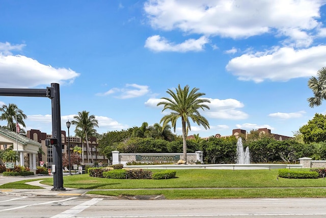 view of property's community with uncovered parking and a lawn