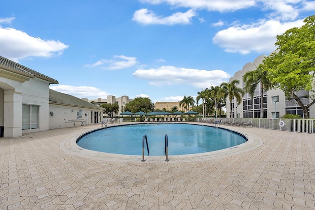 community pool with fence and a patio