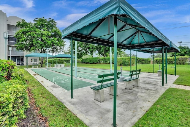 view of home's community featuring a lawn and shuffleboard