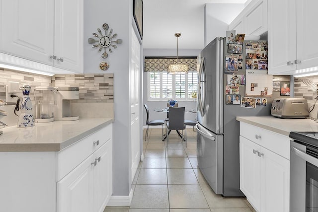 kitchen with light tile patterned floors, range, white cabinetry, and decorative backsplash