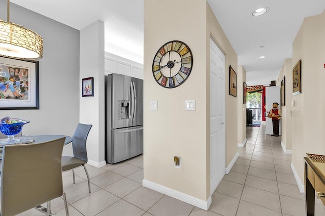 hallway with recessed lighting, baseboards, and light tile patterned flooring