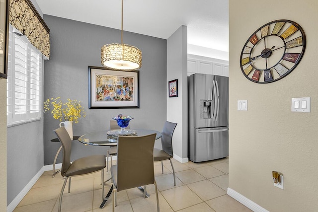 dining space with baseboards and light tile patterned flooring