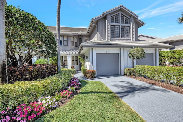 view of front facade with a garage and decorative driveway