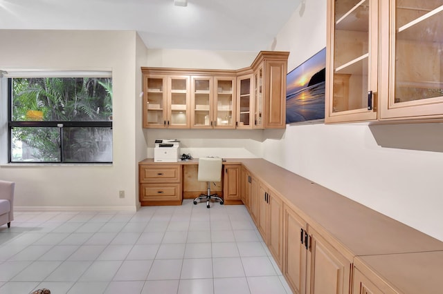 home office with light tile patterned flooring, built in study area, and baseboards