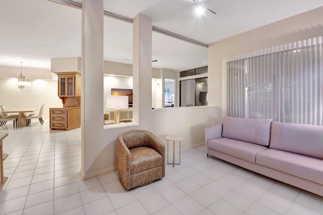 tiled living room featuring rail lighting and baseboards