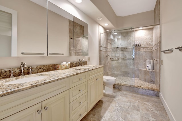 bathroom with a stall shower, a sink, toilet, and double vanity