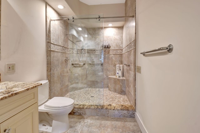 full bathroom with vanity, a shower stall, and toilet