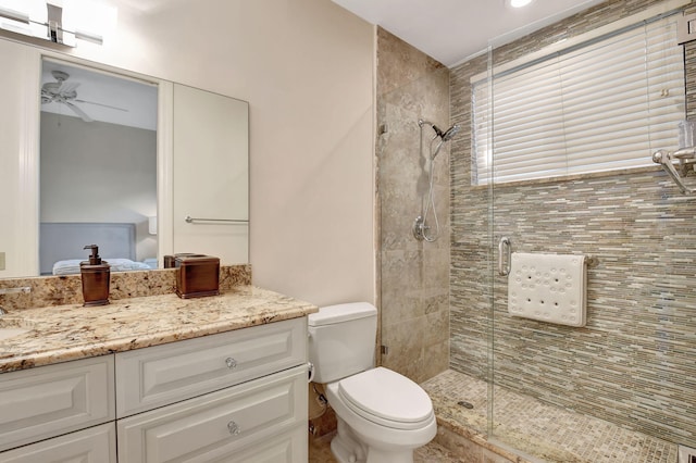 full bathroom featuring toilet, vanity, a shower stall, and a ceiling fan