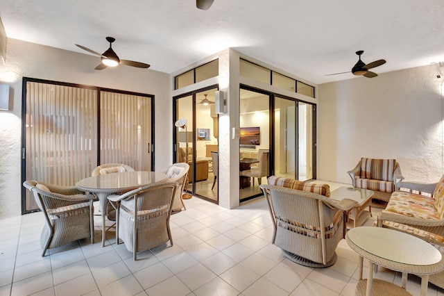 dining room with light tile patterned floors, a textured wall, and a ceiling fan