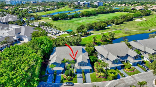 drone / aerial view with a water view, view of golf course, and a residential view