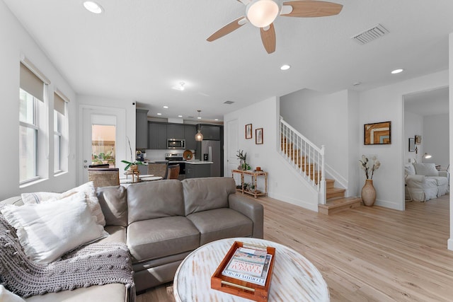 living area with visible vents, baseboards, stairway, recessed lighting, and light wood-style floors