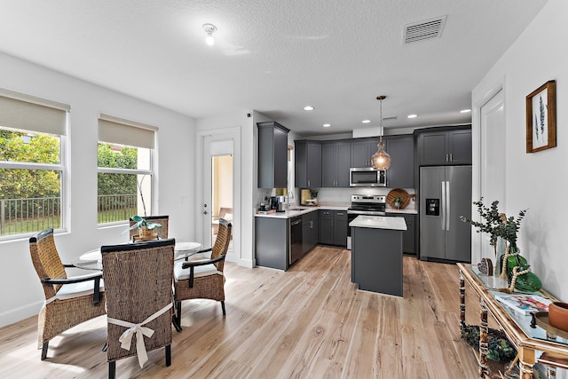 kitchen with visible vents, light wood-type flooring, a sink, appliances with stainless steel finishes, and light countertops