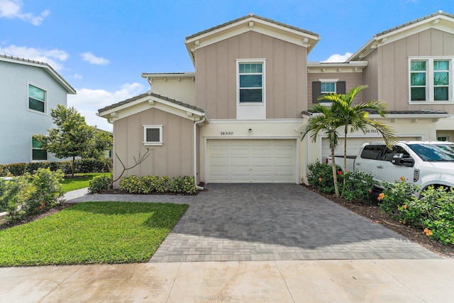 view of front of home with decorative driveway, board and batten siding, and an attached garage