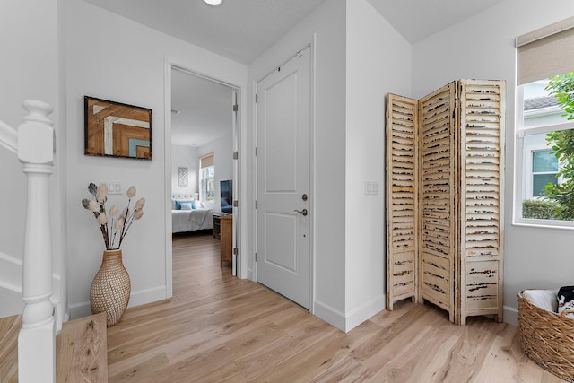 hallway with baseboards and light wood-style floors