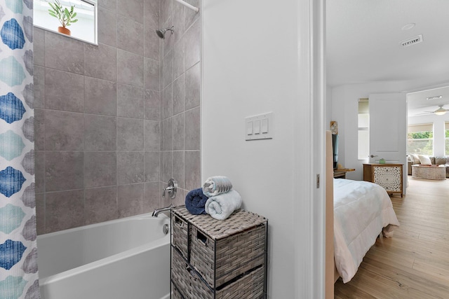 ensuite bathroom featuring visible vents, shower / tub combo with curtain, a ceiling fan, wood finished floors, and connected bathroom