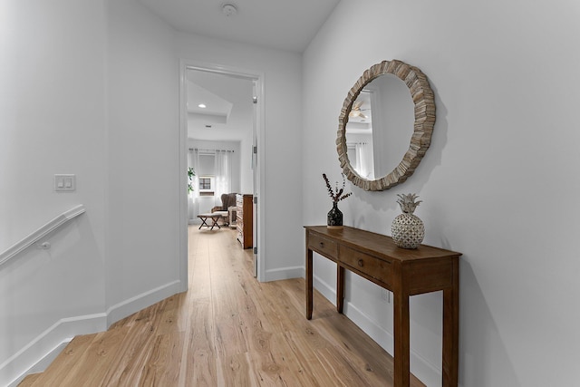 hall featuring baseboards and light wood-type flooring