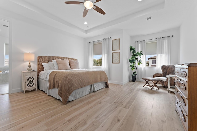 bedroom featuring visible vents, recessed lighting, baseboards, light wood finished floors, and a raised ceiling