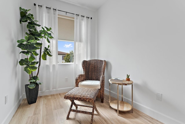 living area featuring baseboards and light wood-style floors