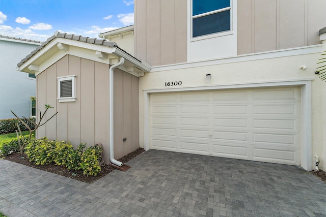 garage with decorative driveway