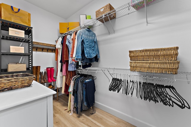 walk in closet with light wood-style floors