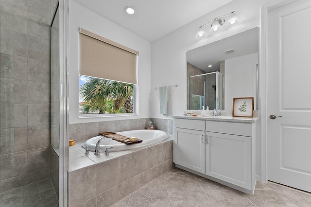 bathroom with tile patterned flooring, visible vents, a stall shower, a bath, and vanity