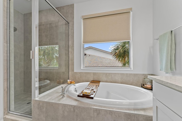 full bath with vanity, a bath, and a shower stall