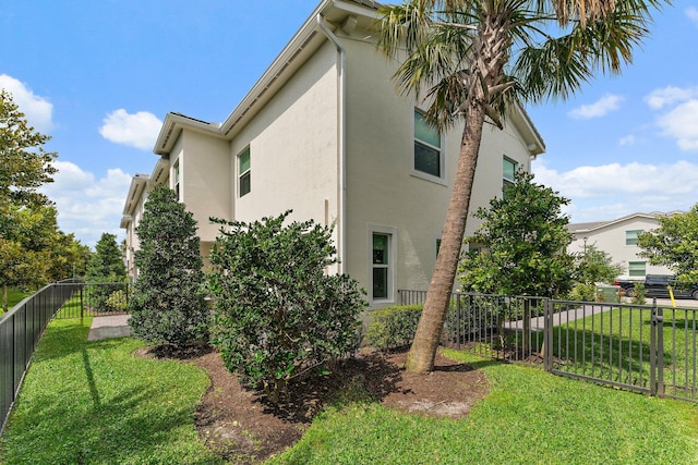 view of property exterior featuring a yard, a fenced backyard, and stucco siding