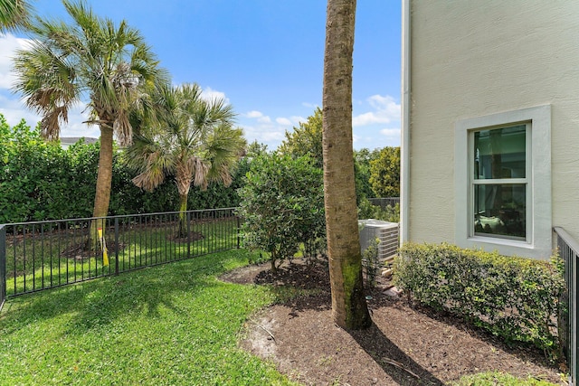 view of yard featuring central AC unit and fence