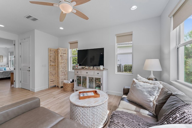 living room featuring visible vents, a healthy amount of sunlight, and wood finished floors