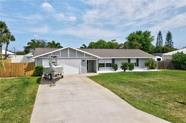 ranch-style house with a garage, driveway, fence, and a front lawn