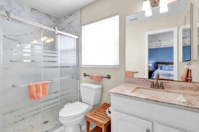 bathroom featuring vanity, a stall shower, toilet, connected bathroom, and visible vents