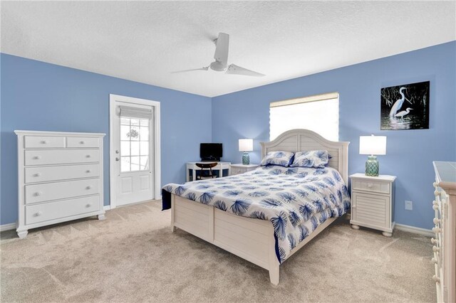 bedroom with baseboards, a ceiling fan, light colored carpet, and a textured ceiling