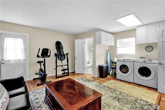 washroom with cabinet space, light tile patterned floors, baseboards, and washer and dryer