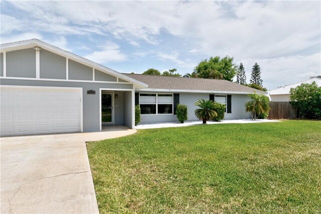 ranch-style house featuring a garage, stucco siding, fence, and a front lawn