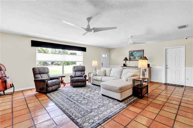 living room featuring light tile patterned floors, a textured ceiling, and a ceiling fan
