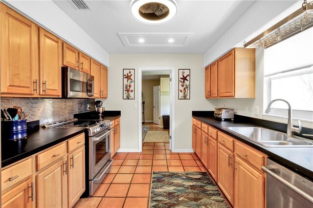 kitchen featuring a sink, visible vents, appliances with stainless steel finishes, and dark countertops