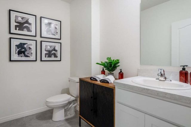 bathroom featuring vanity, tile patterned flooring, toilet, and baseboards