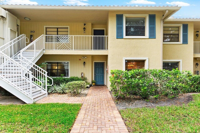 multi unit property with stairway, metal roof, and stucco siding