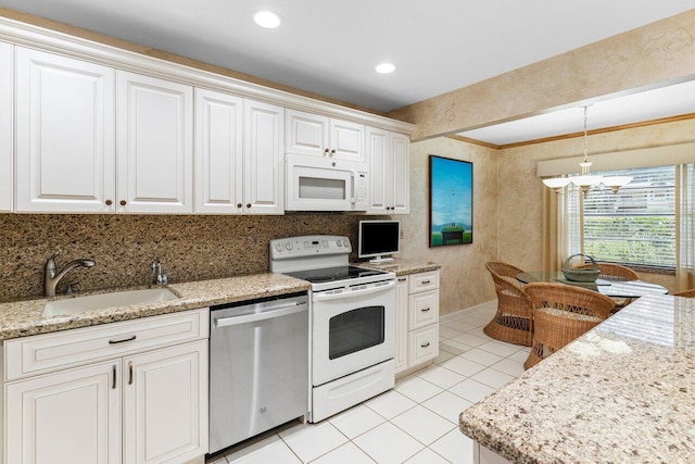 kitchen with light tile patterned flooring, hanging light fixtures, white cabinets, white appliances, and a sink